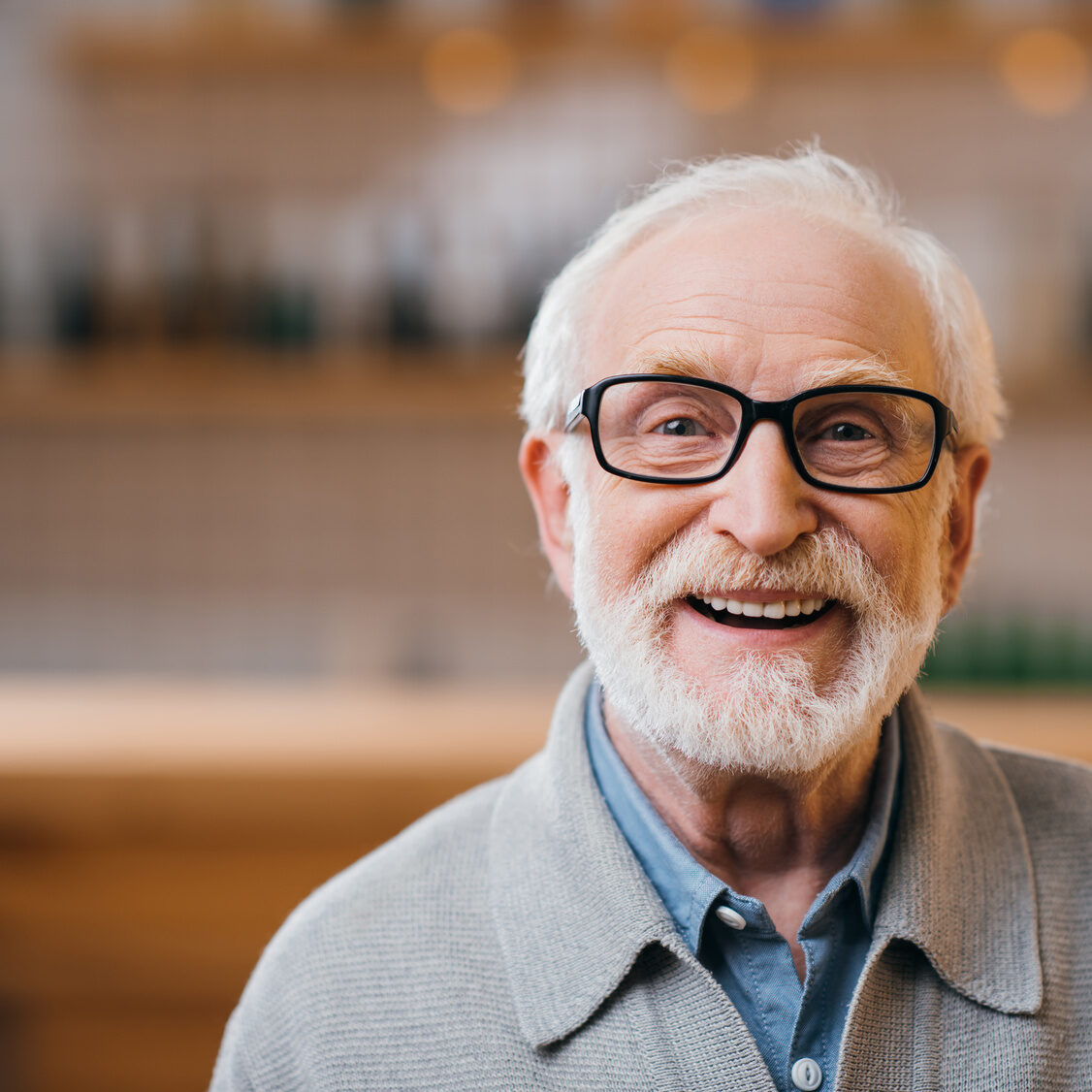 Glücklicher alter Mann mit Brille