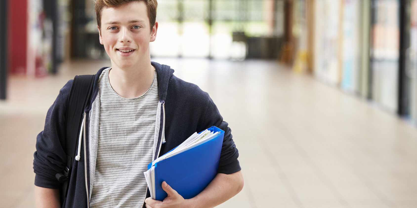 Portrait Of Male Student Standing In College Building