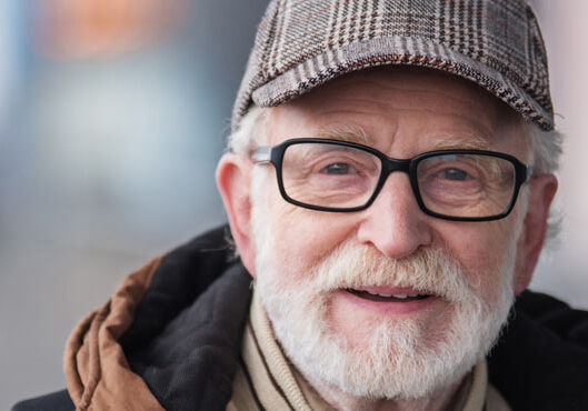 Älterer Mann mit kariertem Hut und Brille